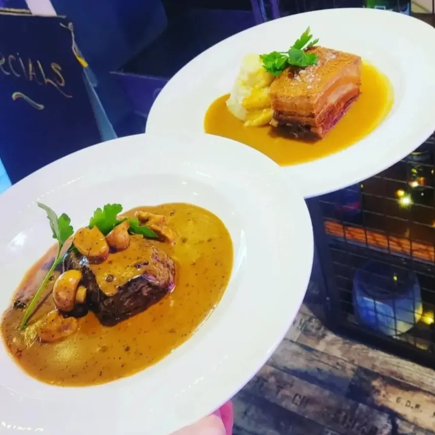 Two plates with mushrooms and sauce